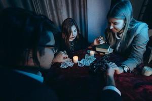 les gens se tiennent la main de nuit à table avec des bougies photo