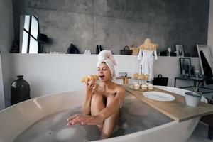 femme de mode de luxe le matin prendre le petit déjeuner allongé dans le bain photo