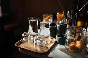 quatre tasses en verre sur le comptoir du bar avec accessoires de service. photo