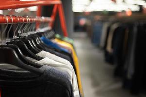 vêtements élégants sur un cintre dans un magasin. nouvelle collection de manteaux. photo