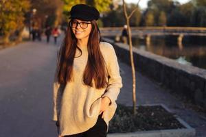 séduisante, jeune brune aux cheveux longs marchant dans le parc d'automne. photo