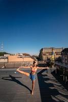 jeune femme pratiquant le yoga sur le toit d'un immeuble photo