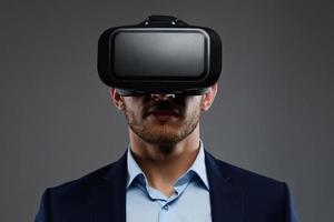 mâle en costume avec des lunettes de réalité virtuelle sur la tête.