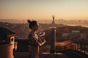 femme faisant du yoga sur le toit d'un gratte-ciel dans une grande ville. photo