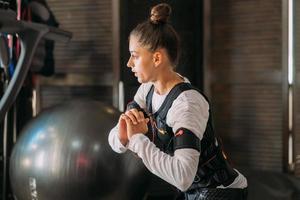 formation EMS. fille faisant des exercices dans un costume avec des câbles. photo