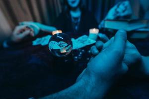 les gens se tiennent la main de nuit à table avec des bougies photo