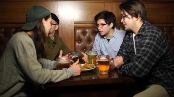 jeunes amis s'amusant ensemble en buvant de la bière dans un pub. photo