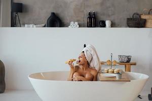 femme de mode de luxe le matin prendre le petit déjeuner allongé dans le bain photo