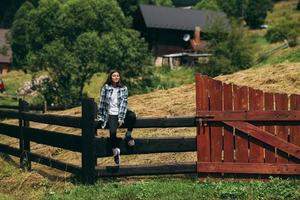 une jeune femme caucasienne attrayante assise sur une clôture photo