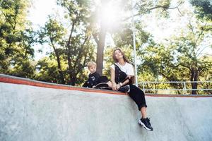 belle jeune maman hipster et petit fils au skatepark photo