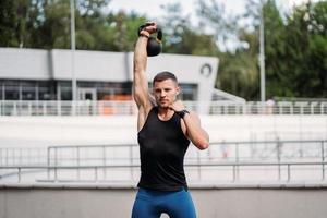 gars sportif s'entraînant avec kettlebell. force et motivation. photo