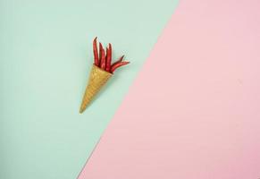 un cornet gaufré avec un tas de piments rouges chauds dans les îles sur un fond coloré photo