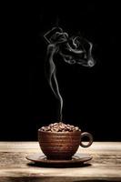 tasse en bois avec des haricots et de la fumée en forme de femme photo