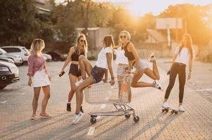 les jeunes femmes avec un chariot de supermarché s'amusent photo