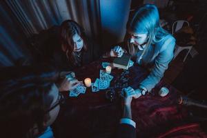 les gens se tiennent la main de nuit à table avec des bougies photo