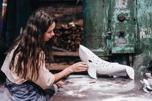 portrait de jeune femme travaille soigneusement sur une baleine en céramique en atelier. photo