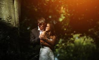 beau couple de mariage posant dans la forêt photo