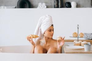 femme de mode de luxe le matin prendre le petit déjeuner allongé dans le bain photo