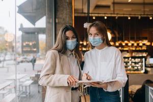 deux femmes d'affaires avec leurs masques faciaux débattant de différents points de vue sur le travail photo