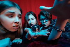 groupe de personnes et femme diseuse de bonne aventure avec boule de cristal photo