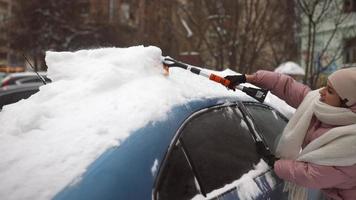 femme enlevant la neige d'une voiture photo