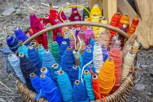bobines de fil de couleur de fil, textiles, arrière-plan. ensemble de fils colorés pour coudre dans un panier. photo