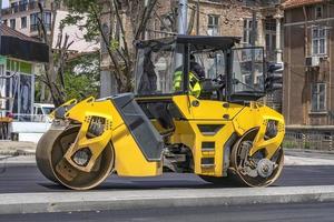 rouleau à tambour faisant une nouvelle route à la ville. vue de côté photo