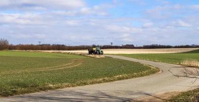 un tracteur avec grande remorque sur une route de campagne par beau temps. photo