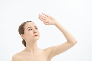 portrait de jeune femme asiatique regardant sur le côté et montrant la main sur fond blanc. photo