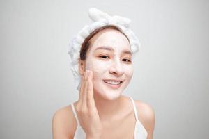 femme asiatique dans une serviette blanche sur la tête avec un masque sur le visage photo