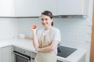 jeune femme asiatique cuisine dans la cuisine. cuisiner à la maison. nourriture saine. concept de régime. photo