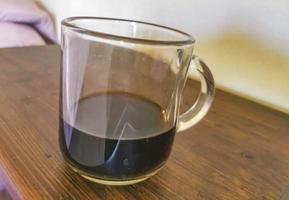 tasse en verre de café noir du Mexique sur fond de bois. photo