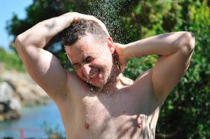 jeune homme relaxant sous la douche photo