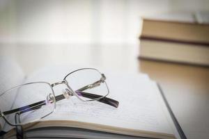 lunettes posées sur un cahier sur une table en bois photo