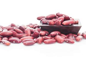 haricots rouges dans une tasse de bois sur blanc photo