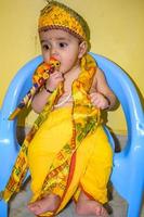 mignon enfant indien déguisé en petit seigneur krishna à l'occasion du festival radha krishna janmastami à delhi inde photo