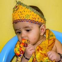 mignon enfant indien déguisé en petit seigneur krishna à l'occasion du festival radha krishna janmastami à delhi inde photo