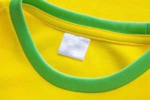 Étiquette de vêtements textiles blanc vierge sur la texture de jersey de tissu de vêtements de sport jaune photo