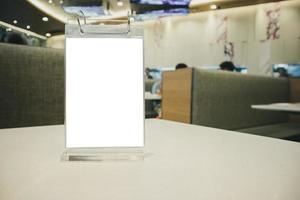 cadre de menu étiquette blanche vide maquette sur table avec fond intérieur de café restaurant photo