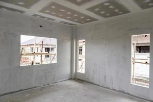 intérieur de la salle vide avec plafond en plaques de plâtre sur le chantier photo