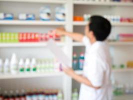 flou pharmacien prenant des médicaments de l'étagère de la pharmacie photo