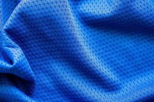 maillot de football de vêtements de sport en tissu de couleur bleue avec fond de texture en maille d'air photo