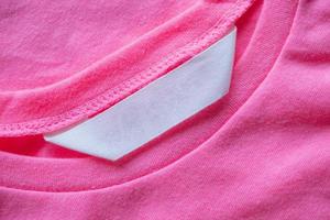 étiquette de vêtements de soin de blanchisserie vierge sur chemise rose photo