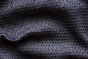 maillot de football de vêtements de sport en tissu noir avec fond de texture en maille d'air photo