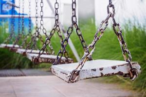 vieille balançoire en bois dans le parc de jeux photo