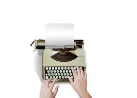 Main de femme tapant sur une vieille machine à écrire isolée sur fond blanc photo