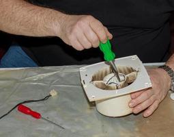 gros plan d'un ventilateur d'extraction de cuisine très sale. ventilateur avant le nettoyage préventif et le lavage. processus de démontage photo