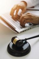 avocat masculin travaillant avec des documents contractuels et un marteau en bois sur table dans la salle d'audience. justice et droit, avocat, juge de la cour, concept. photo