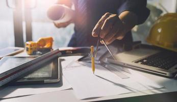 Deux collègues discutant des données de travail et tablette, ordinateur portable avec sur le projet architectural sur le chantier de construction au bureau au bureau photo