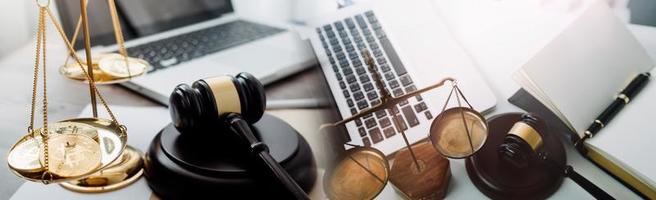 concept de justice et de droit. juge masculin dans une salle d'audience avec le marteau, travaillant avec, clavier d'ordinateur et d'accueil, lunettes, sur table à la lumière du matin photo